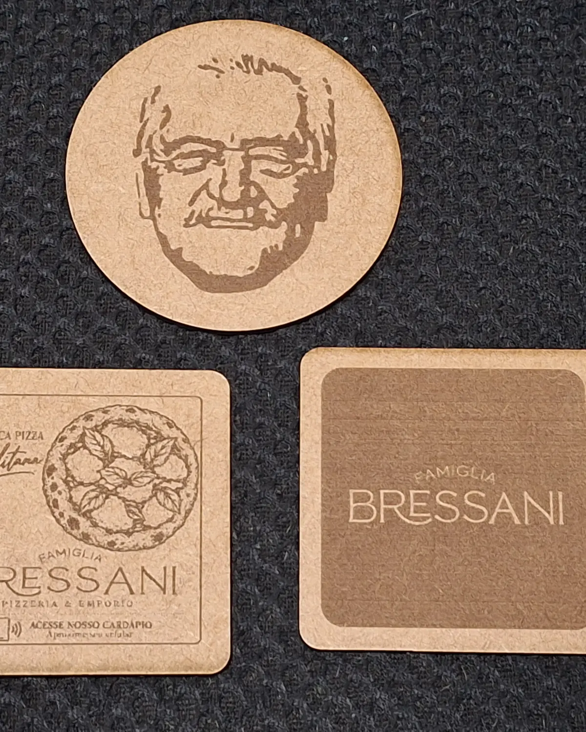 Porta-copos de MDF gravados a laser com a marca de uma pizzaria e um retrato